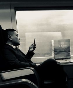 Side view of man sitting in bus