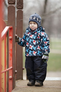 Full length of boy standing at playground during winter