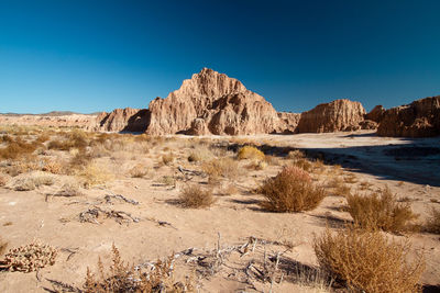 Rock formations in desert against clear blue sky