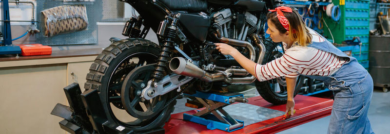 Mechanic reviewing engine of motorbike on factory