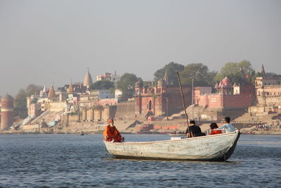 Boats in river with buildings in background