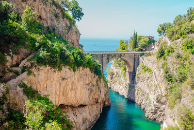 Arch bridge over river against sky