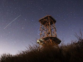 Traditional windmill on field against sky at night