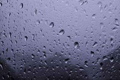 Water drops on glass against blurred background