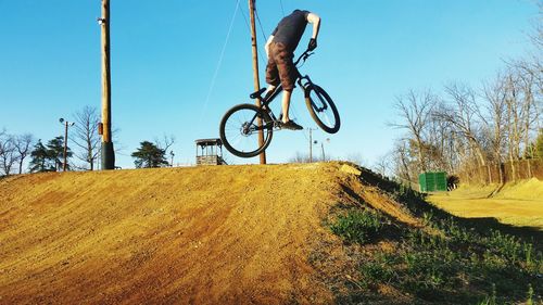 Bicycle on landscape against clear sky