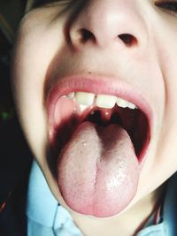 Close-up of boy sticking out tongue at home