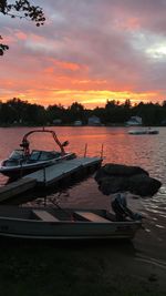 Boat moored on beach against sky during sunset