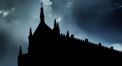 Low angle view of silhouette temple against sky