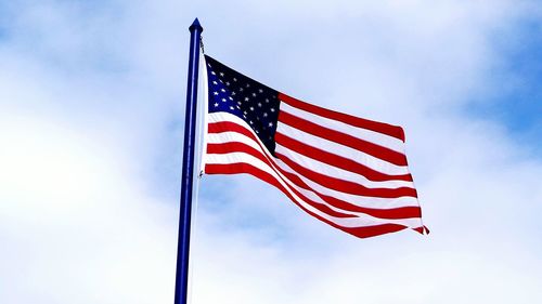 Low angle view of american flag against cloudy sky