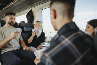 Family enjoying and having fun while playing cards in train