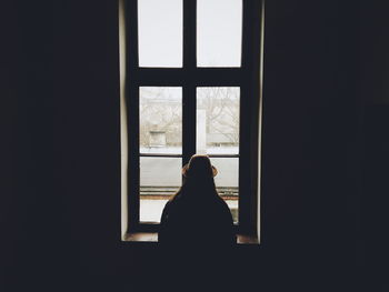 Rear view of silhouette man in window