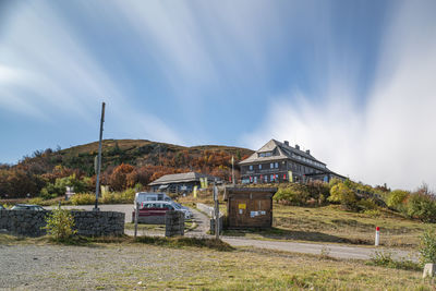 Built structure on field by mountain against sky