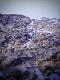 Close-up of snow on beach against sky