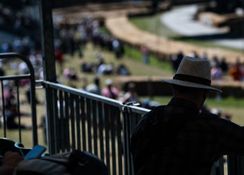 Rear view of man sitting on railing