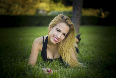 Portrait of smiling woman lying on grass