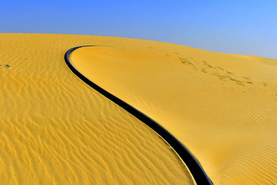 Desert sand decided by one abstract black cable line , an abstract artwork