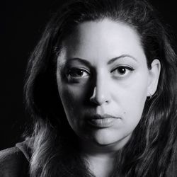 Close-up portrait of a beautiful young woman over black background