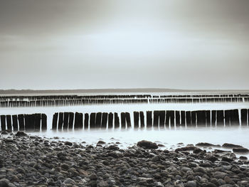 Scenic view of water flowing through rocks against sky