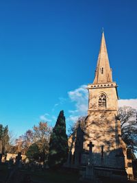 View of trees and church against blue sky