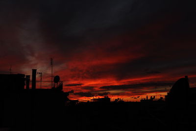 Silhouette built structures against sky during sunset