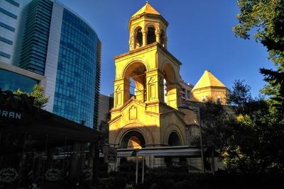 Low angle view of building and trees against sky