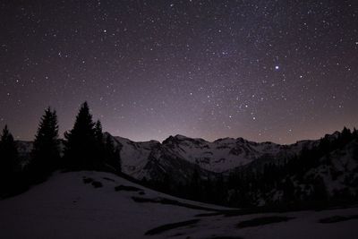 Scenic view of snowcapped mountains against sky at night