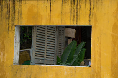 Close-up of yellow window of old building