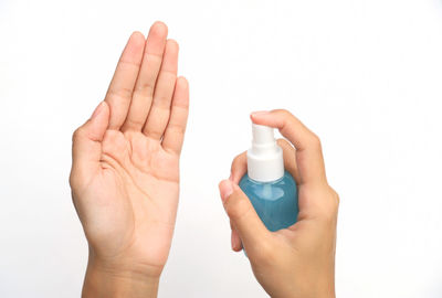 Close-up of hand holding hands over white background