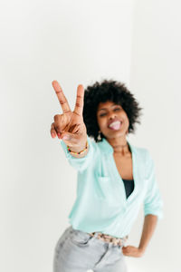 Smiling young woman standing against white background