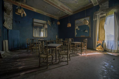 Empty chairs and tables in abandoned building