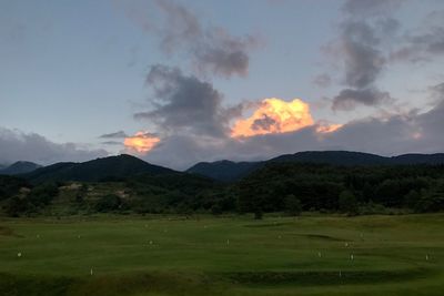 Scenic view of field and mountains against sky