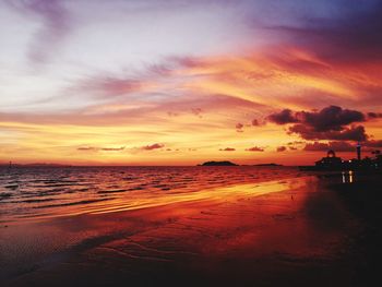 Scenic view of sea against dramatic sky during sunset