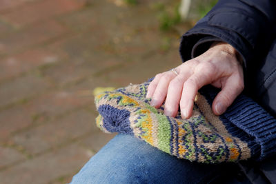 Midsection of person sitting with knit hat on lap