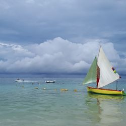 Sailboats in sea against sky