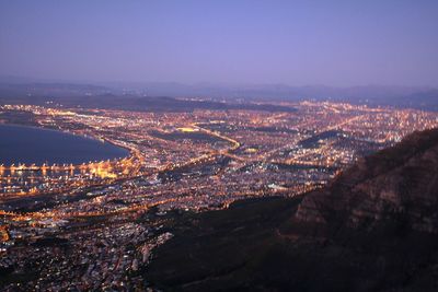 High angle view of illuminated city against sky at night