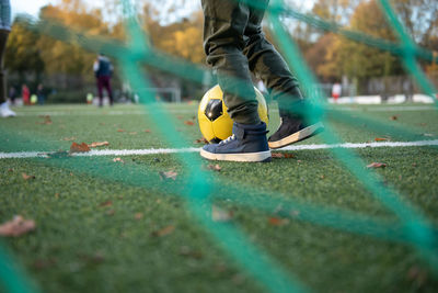 A little boy plays soccer with his father on the soccer field