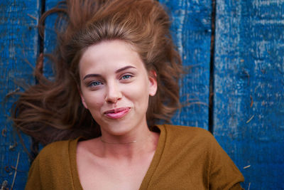 High angle view portrait of beautiful young woman lying on wood paneling