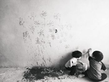 Boys painting wall with hand prints