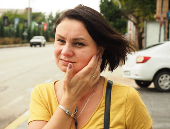 Close-up of mature woman looking away while standing in city