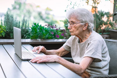 Senior woman using computer at cafe