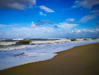 Scenic view of beach against blue sky