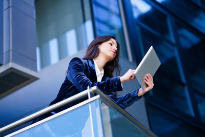 Low angle view of woman standing on railing