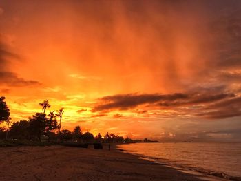 Scenic view of beach against dramatic sky