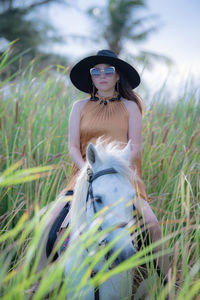 Young woman wearing hat standing on field