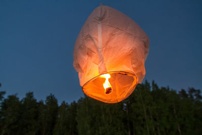 Low angle view of paper lantern flying against clear sky