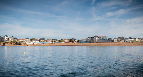 View of townscape by sea against sky