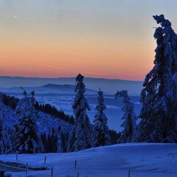 View of snow covered landscape at sunset