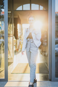 Full length of young woman leaving from store