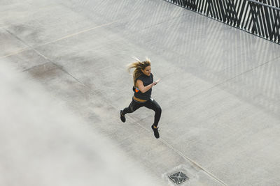 High angle view of woman running on footpath
