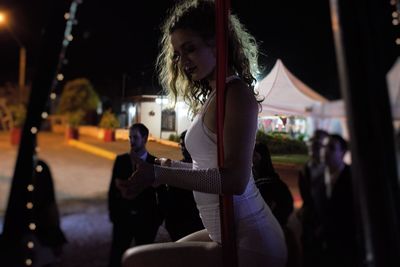 Young woman in city at night